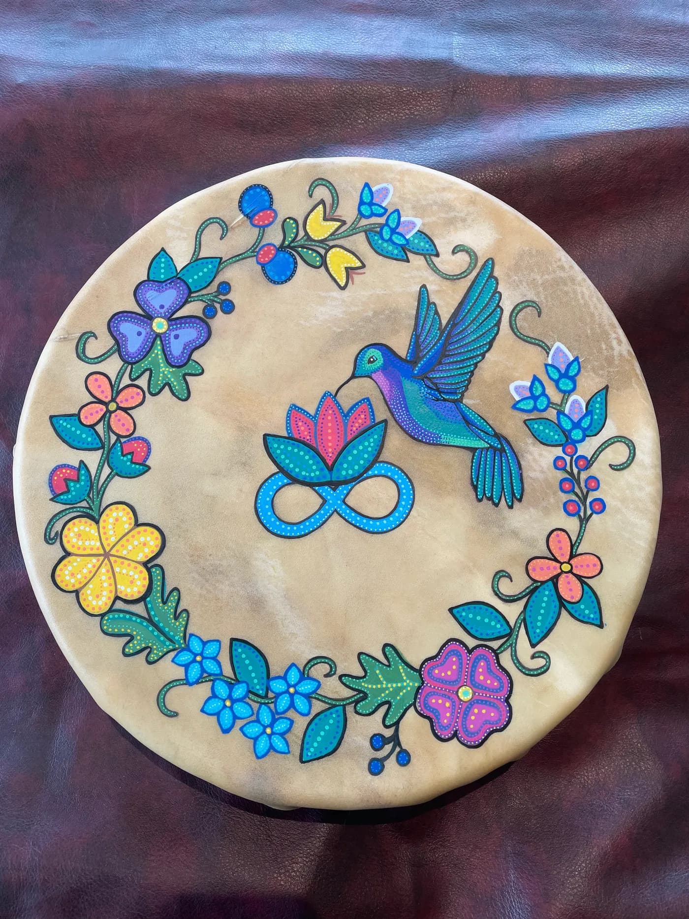 Painted deerhide drum with a hummingbird and flower wreath