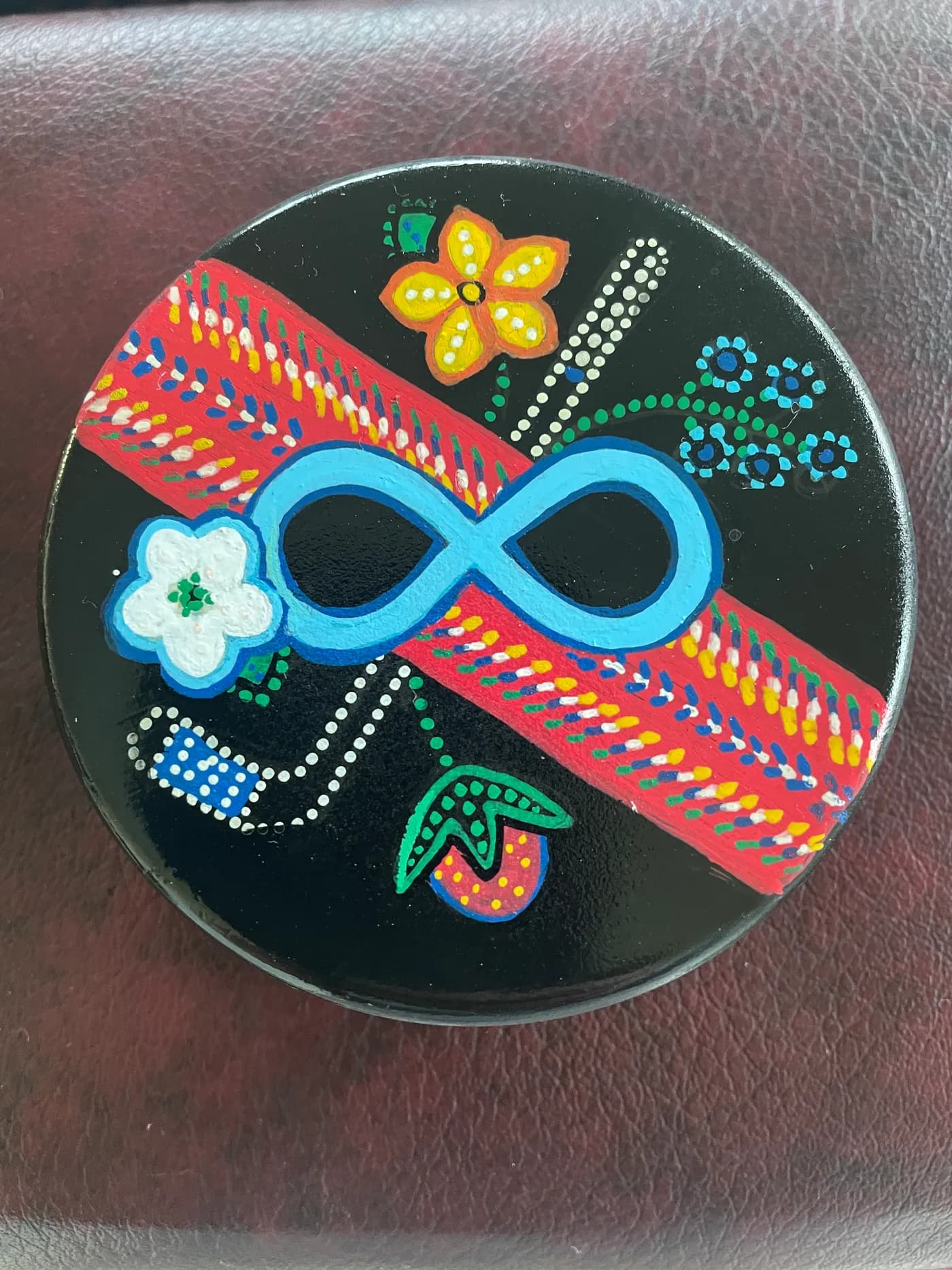 Hand-painted hockey puck with an infinity symbol and beaded flowers