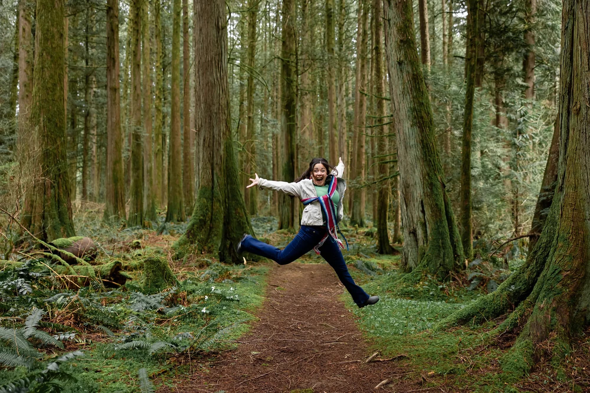 Michelle leaping on a forest path